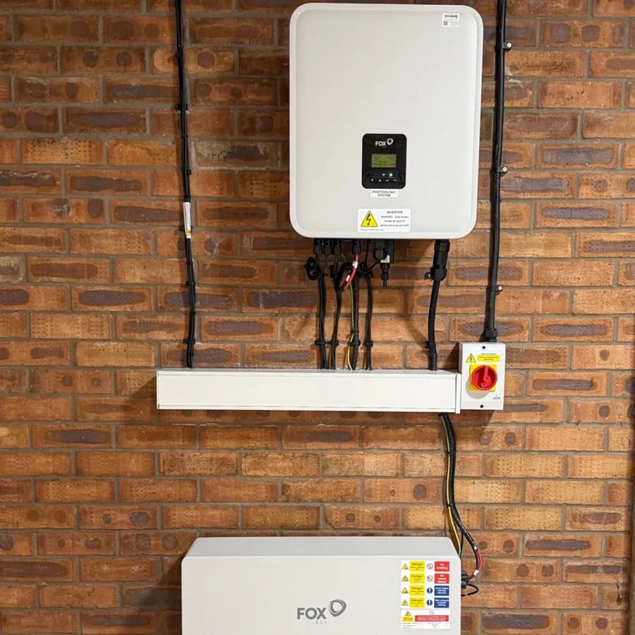 Fox ESS inverter and battery storage unit installed on a brick wall with tidy cable runs