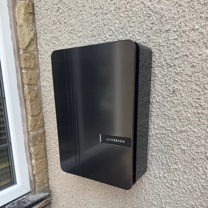 Andersen A2 EV charger installed on a rendered house wall