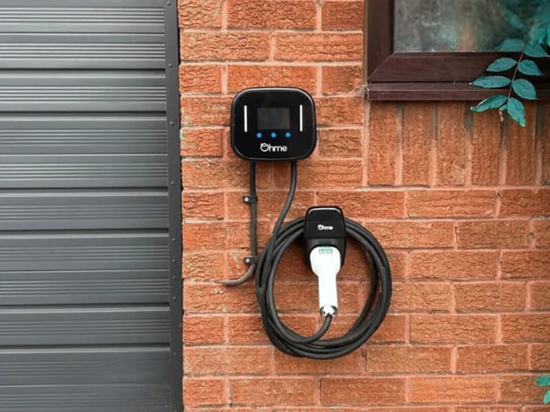 Ohme Home Pro EV charger installed on a house wall with the cable neatly coiled