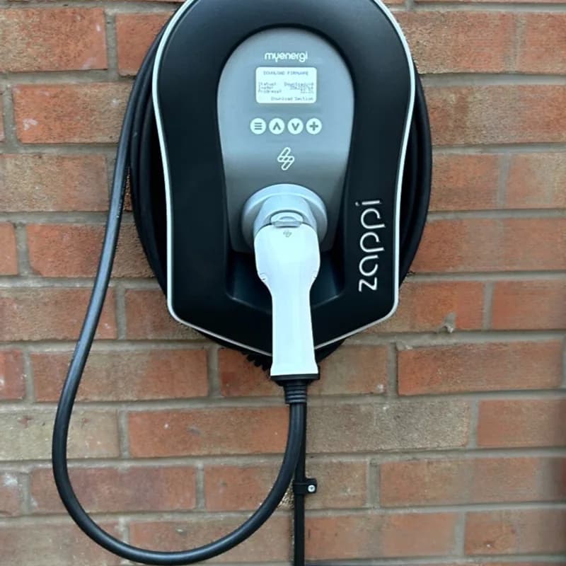 Close-up of a myenergi Zappi EV charger installed on a brick wall