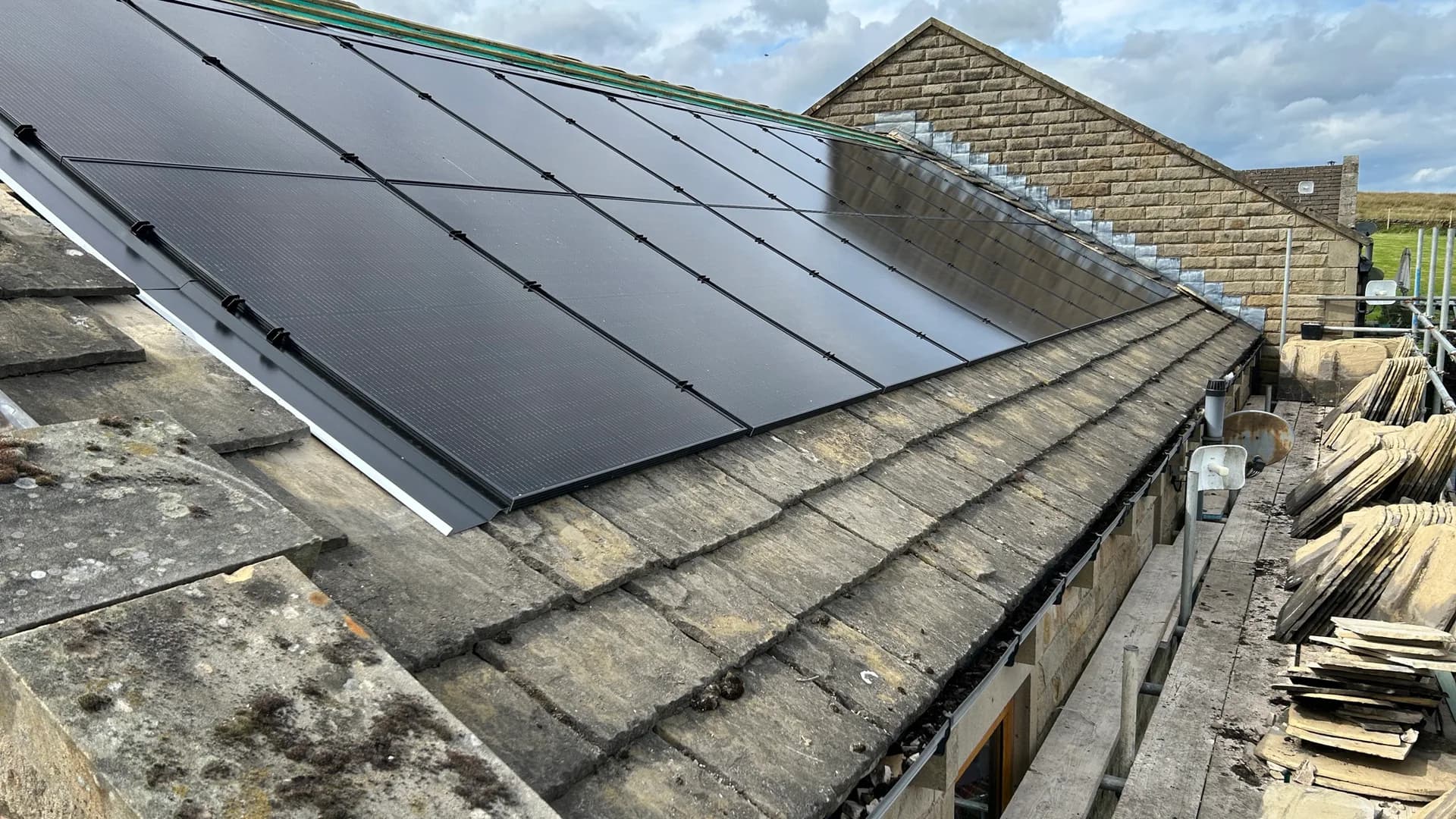 All-black solar panels installed on a stone farmhouse roof in West Yorkshire